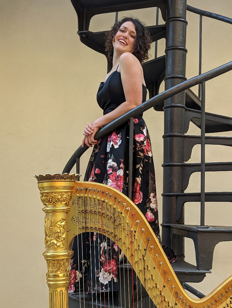 Kaitlin with gold harp on a spiral staircase