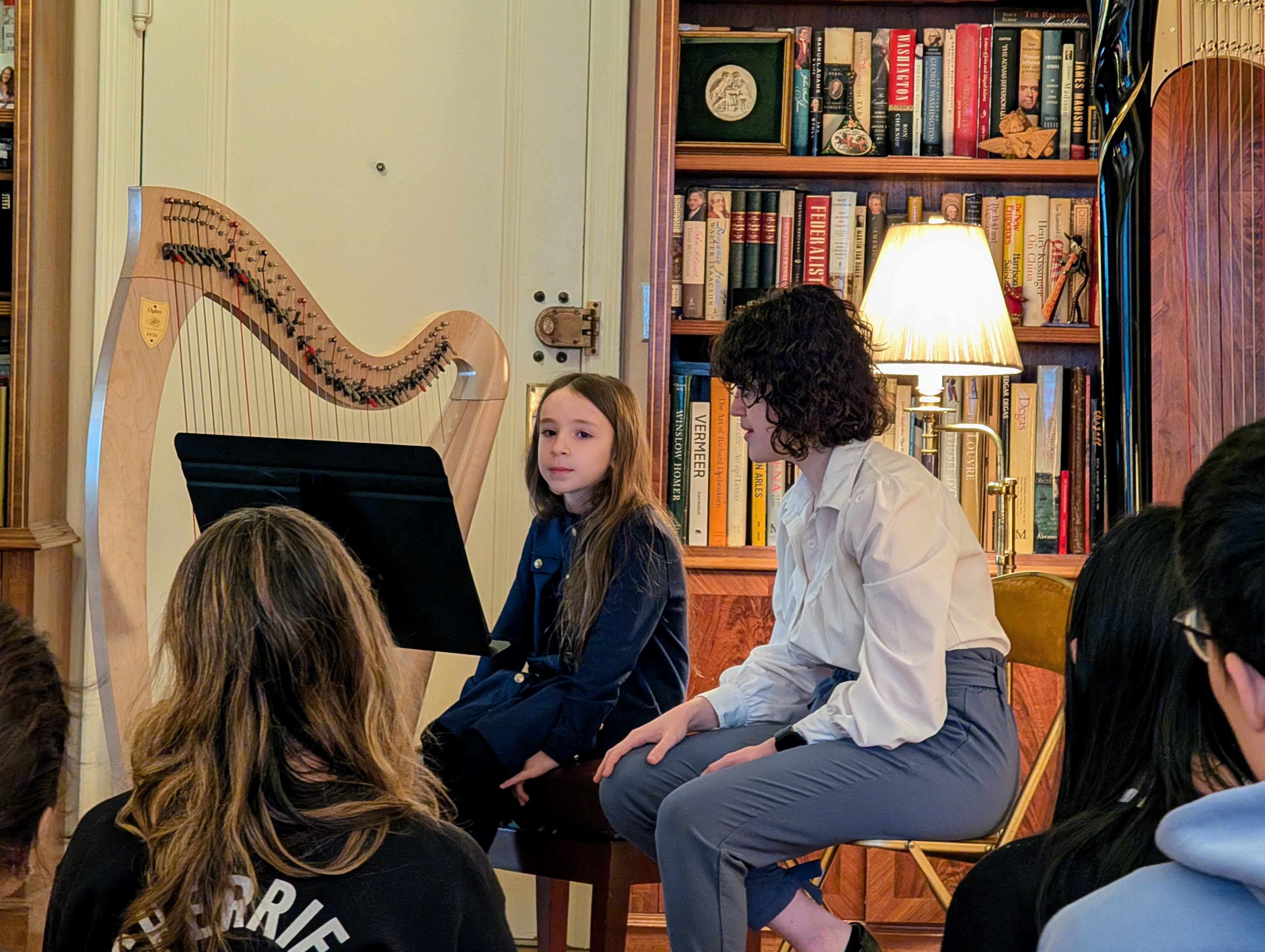Kaitlin teaching a student at a harp recital